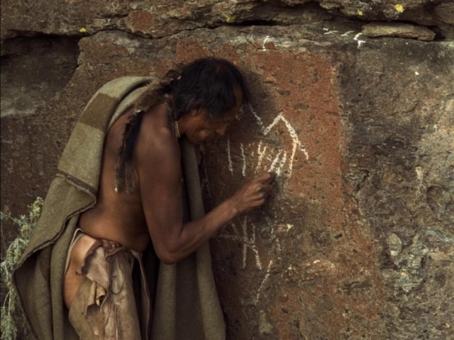 L'indien dessine des inscriptions sur le mur dans La Dernière Piste