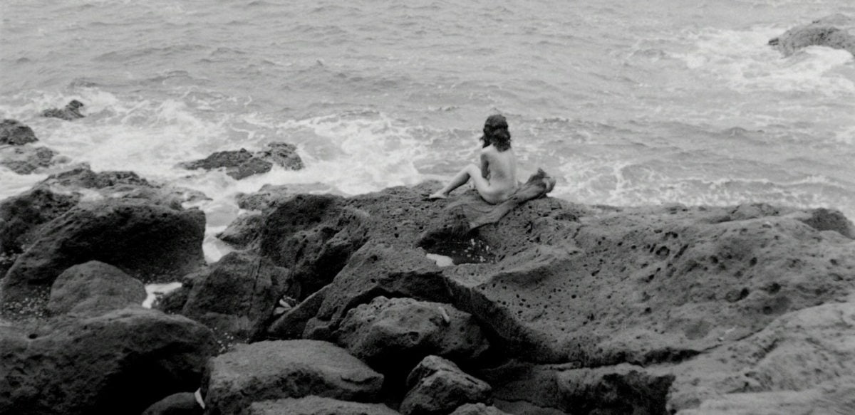 Akemi Negishi sur les rochers devant la mer dans Fièvre sur Anatahan