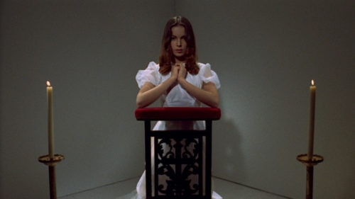 Alice (Anicée Alvina) sur une chaise en train de prier dans Glissements progressifs du plaisir