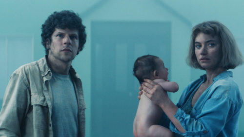 Gemma (Imogen Poots) et Tom (Jesse Eisenberg) avec leur enfant devant leur maison dans Vivarium