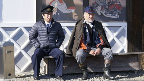 Les deux personnages principaux assis sur un banc dans Extro