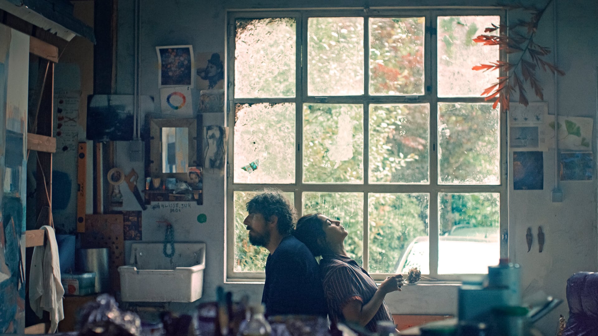 Leïla (Leïla Bekhti) et Damien (Damien Bonnard) assis dos à dos dans l'atelier dans Les Intranquilles
