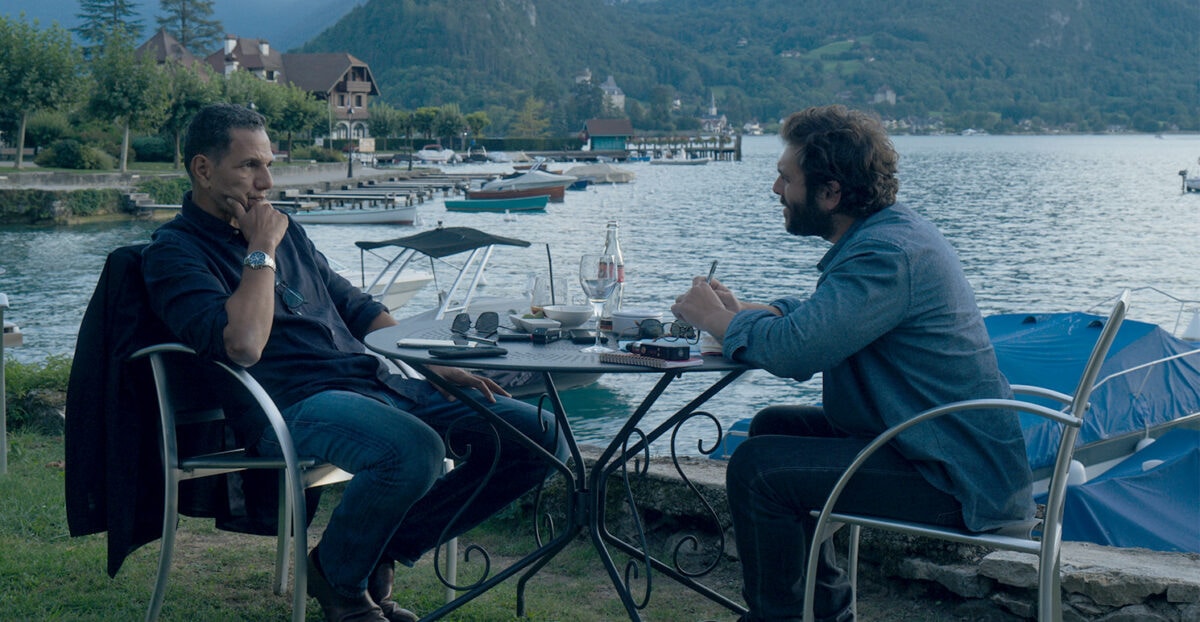 Hubert Antoine (Roschdy Zem) et Stéphane Vilner (Pio Marmaï) discutent au bord d'un lac dans Enquête sur un scandale d'État