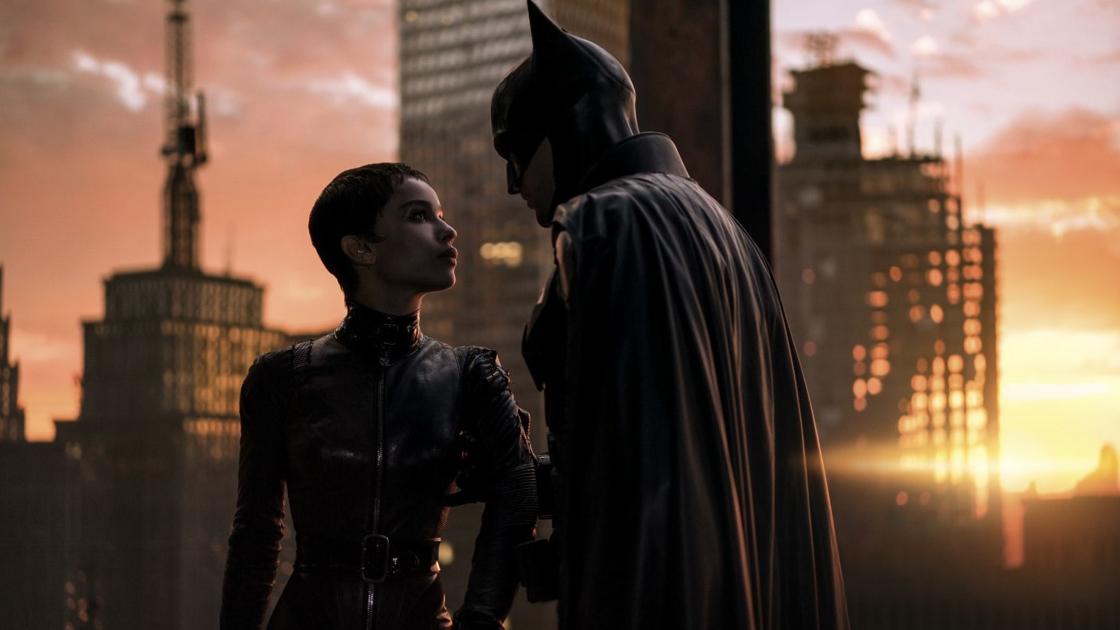 Batman (Robert Pattinson) embrassant Catwoman (Zoë Kravitz) sur le toit d'un immeuble de Gotham dans The Batman