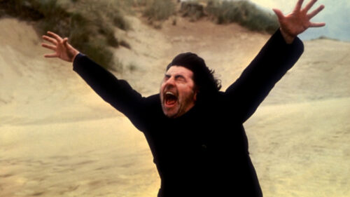 Alan Bates crie sur la plage dans Le Cri du sorcier
