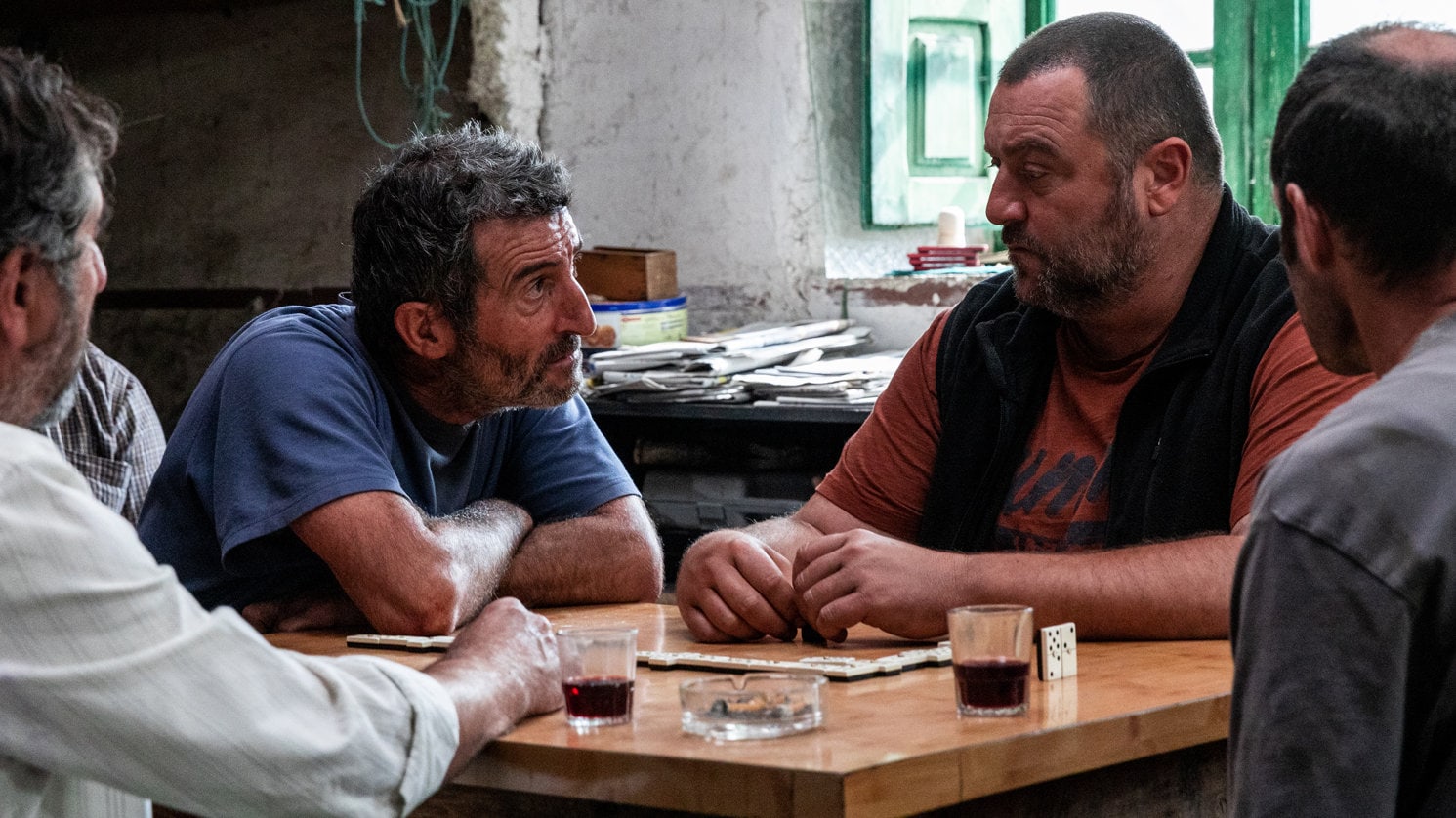 Xan (Luis Zahera) et Antoine (Denis Ménochet) parlent à table au bar dans As Bestas