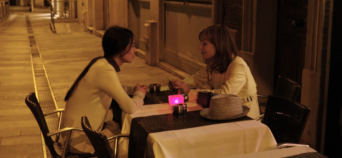 Kim Min-hee et Isabelle Huppert dans un restaurant la nuit dans La Caméra de Claire