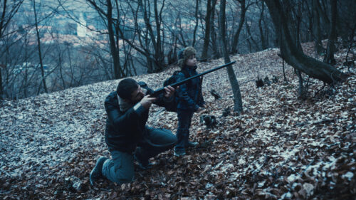 Matthias (Marin Grigore) et son fils tirant sur un ours dans le bois dans R.M.N.