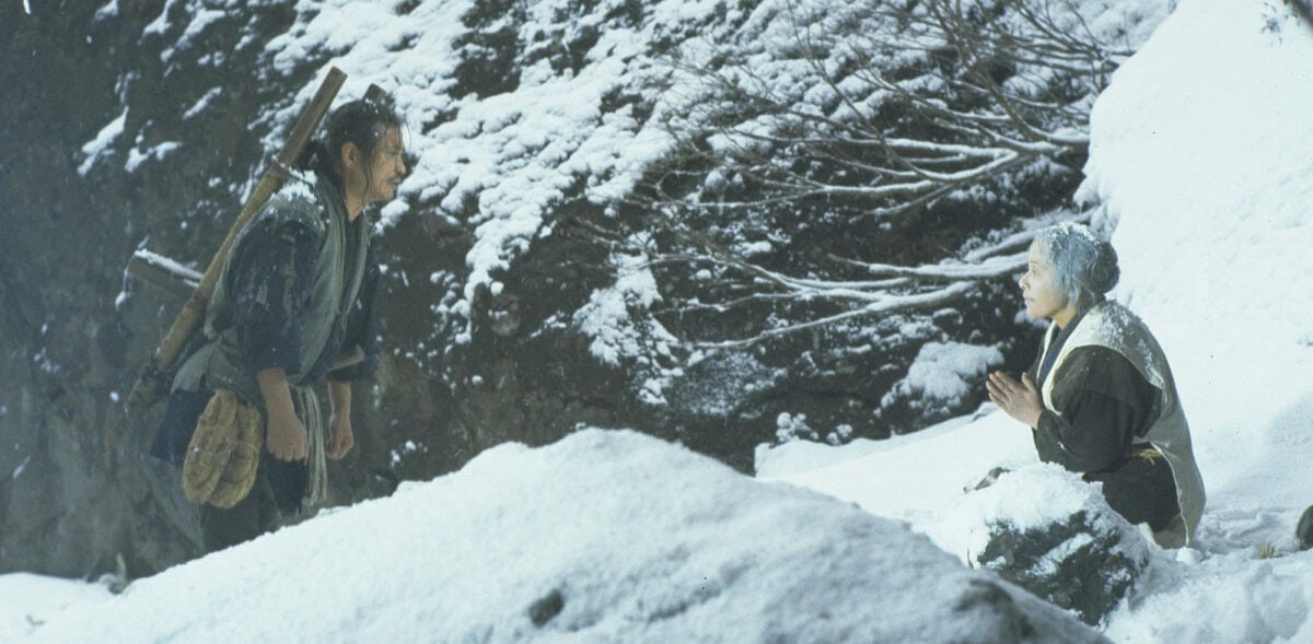 Ken Ogata porte Sumiko Sakamoto dans la neige de la montagne dans La Ballade de Narayama