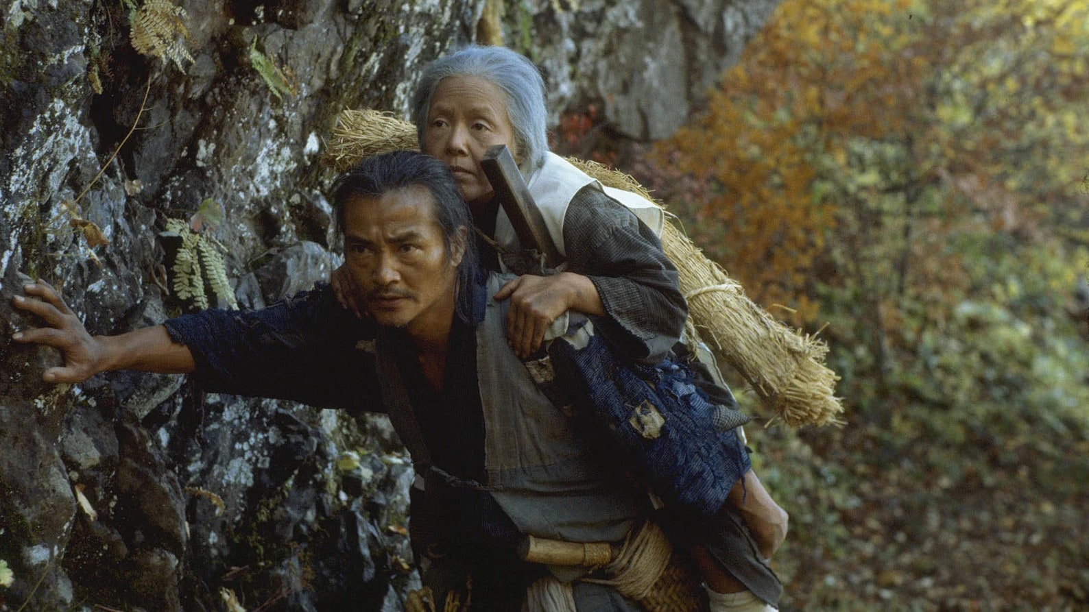 Ken Ogata porte Sumiko Sakamoto dans la montagne dans La Ballade de Narayama