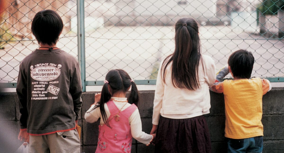 Les enfants livrés face à une grille dans la rue dans Nobody Knows