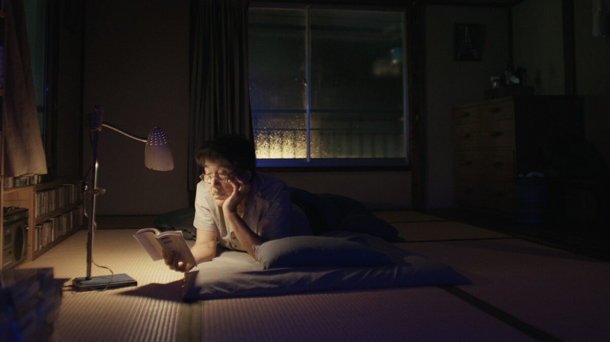 Hirayama (Kōji Yakusho) lit son livre avant de s'endormir dans Perfect days