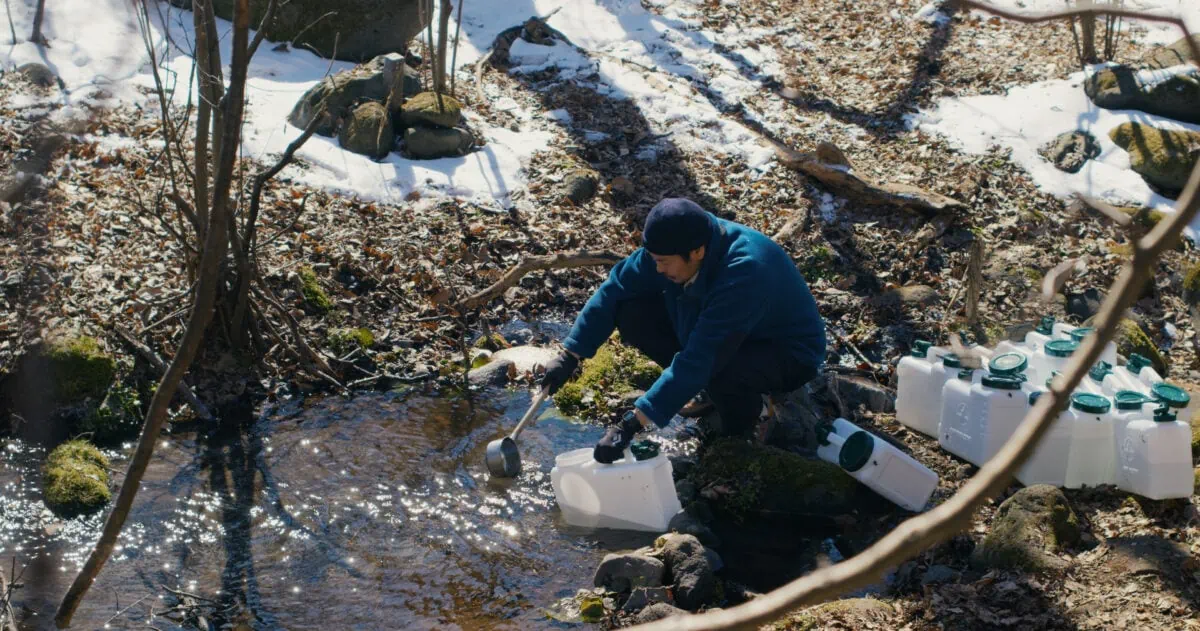 Takumi (Hitoshi Omika) prend de l'eau non potable dans la rivière dans Le Mal n'existe pas