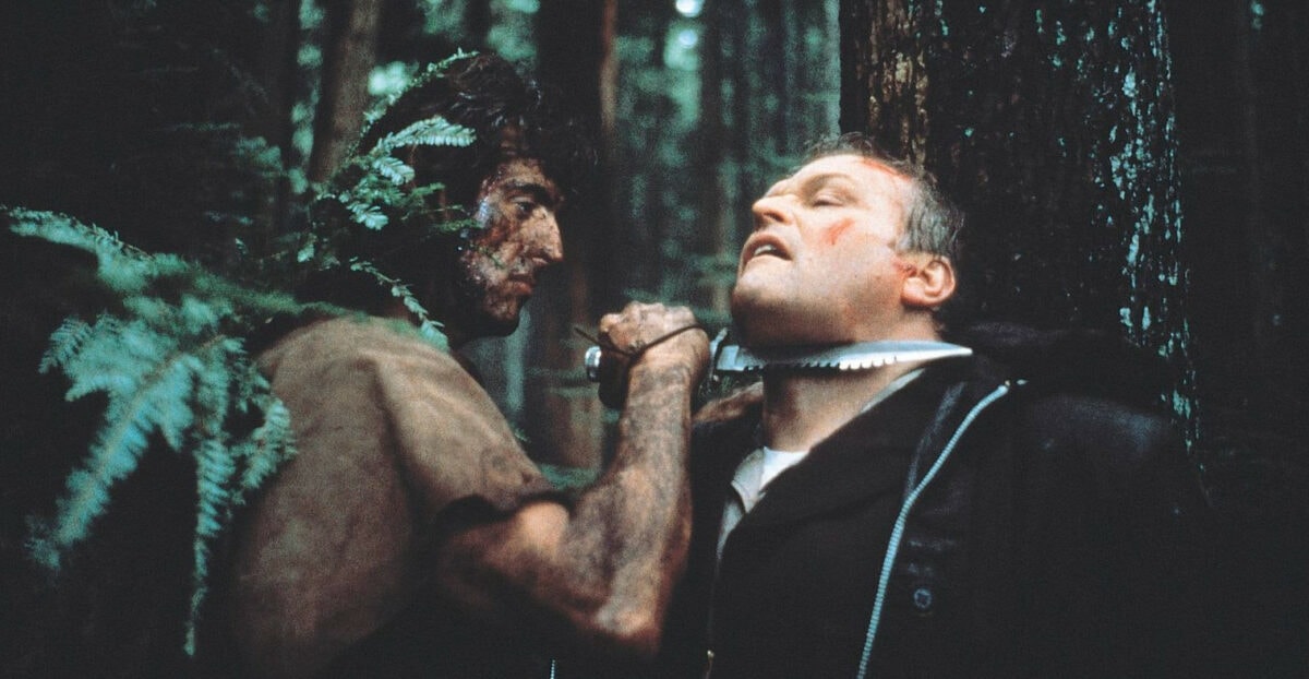 Sylvester Stallone attaquant un homme dans la forêt dans le film Rambo