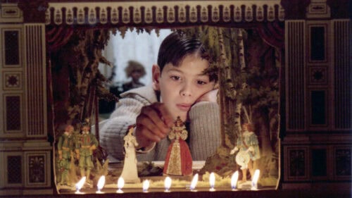 Le garçon jouant avec son petit théâtre dans Fanny et Alexandre