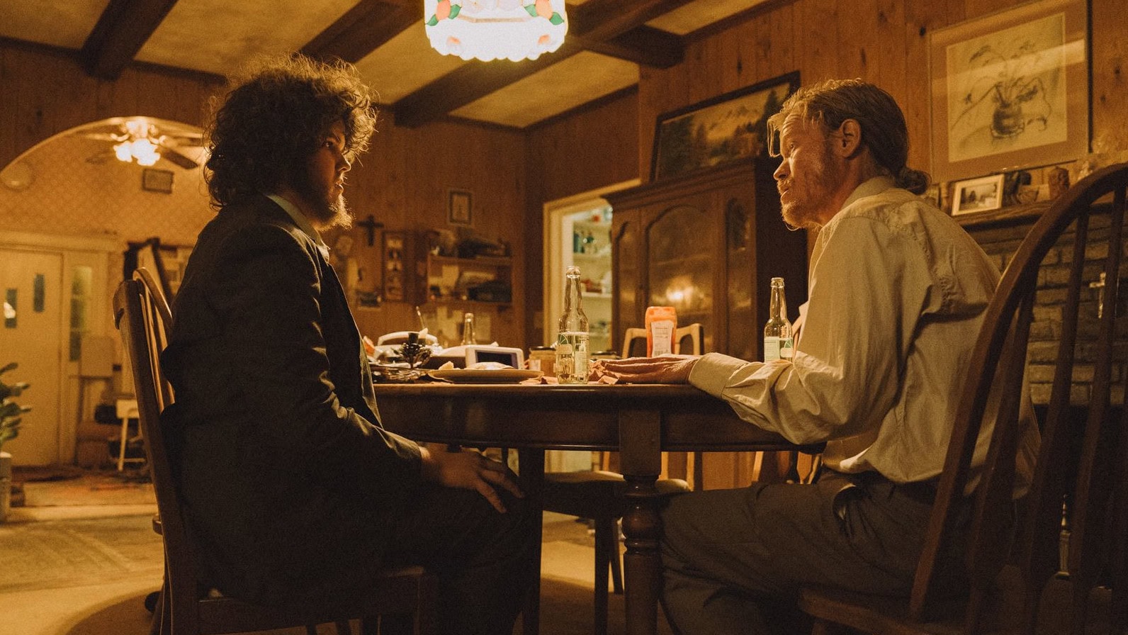 Teddy (Jesse Plemons) et Don (Aidan Delbis) à table dans leur maison dans Bugonia