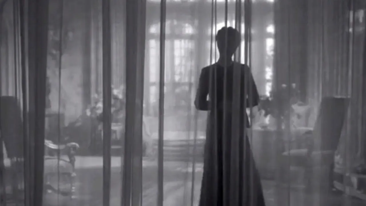 Joan Fontaine derrière le rideau dans Rebecca d'Alfred Hitchcock.