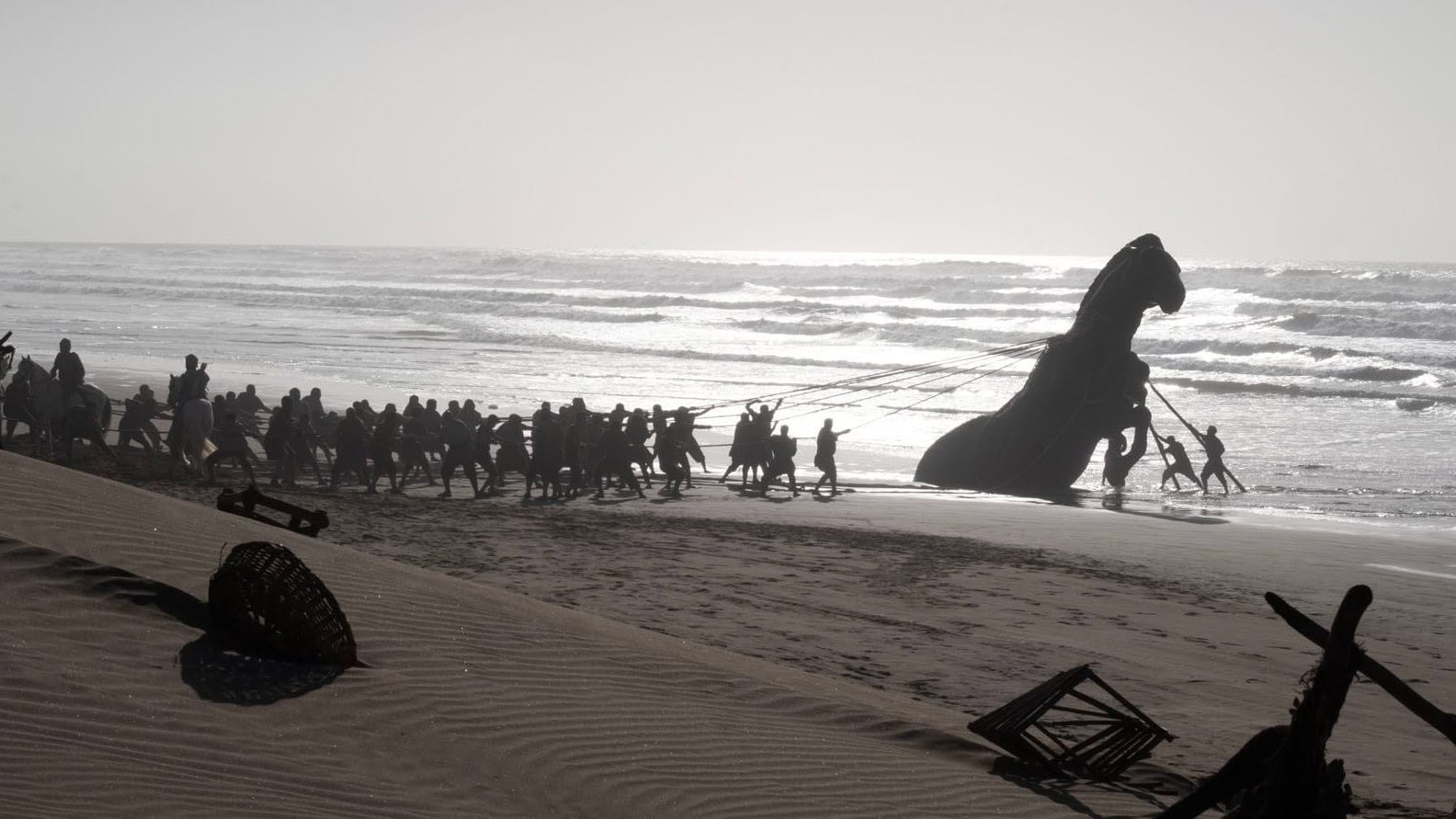 Le cheval de Troie tiré par les troyens sur la plage dans L’Odyssée de Christopher Nolan