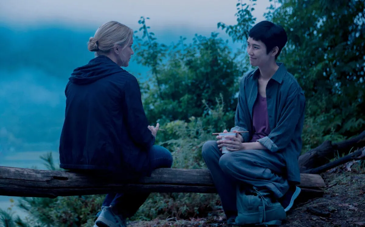 Virginie Efira et Tao Okamoto assises dans la forêt dans Soudain de Ryusuke Hamaguchi